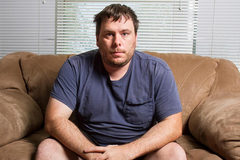 um homem acima do peso sentado no sofá